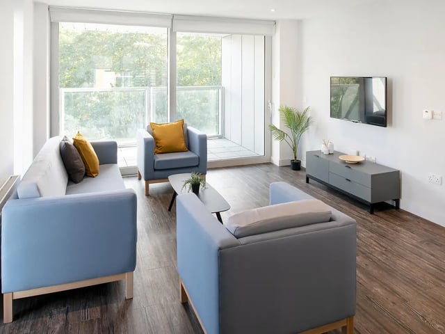 Blue sofas coffee table television living room at Amnis House in Cork Student Accommodation