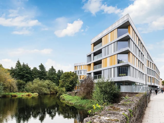 Modern student accommodation building river trees exterior at Amnis House in Cork Student Accommodation