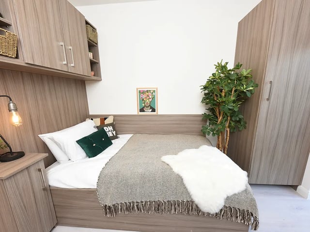 Bed with plant art and wardrobe bedroom at Melbourn Point in Cork Student Accommodation