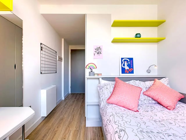 Bed with pink pillows artwork and shelves bedroom at Ardcairn House in Dublin Student Accommodation