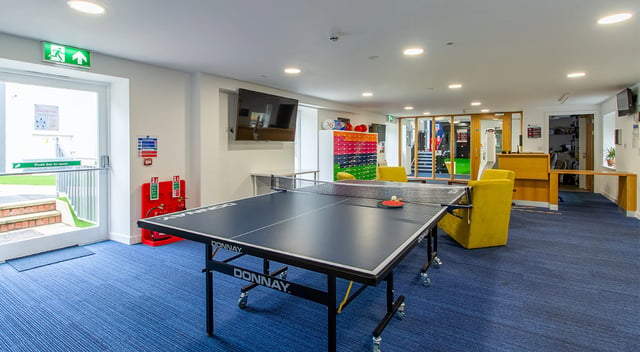 Ping pong table lounge area with yellow chairs at Goods Corner in Edinburgh Student Accommodation