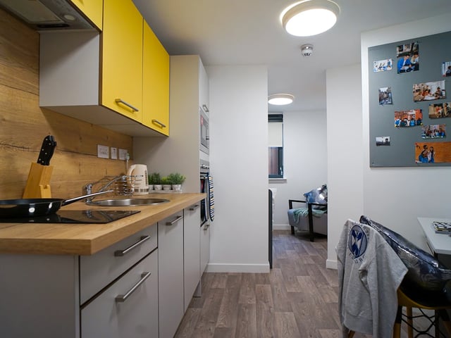 Modern kitchen with yellow cabinets sink and chairs kitchen at Goods Corner in Edinburgh Student Accommodation