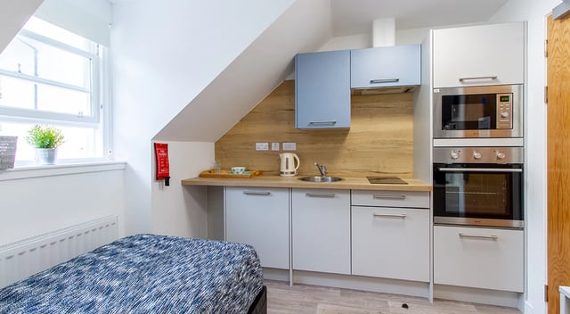 Bed fire blanket sink kettle microwave oven kitchen at Goods Corner in Edinburgh Student Accommodation