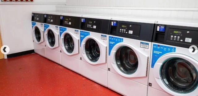 Row of coin operated washing machines laundry room at Marybone Student Village 3 in Liverpool Student Accommodation