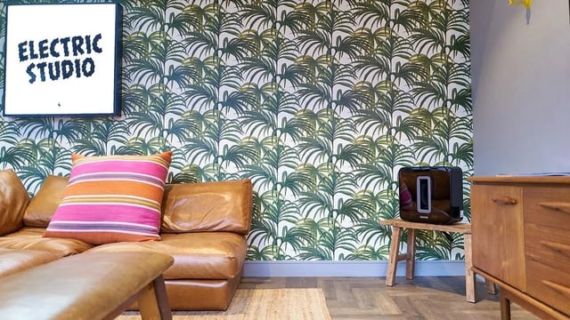 Brown sofa Sonos speaker tropical wallpaper living room at Canvas The Parade in Cardiff Student Accommodation