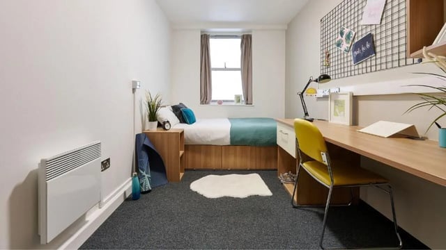 Bed heater desk and yellow chair bedroom at Northernhay House in Exeter Student Accommodation