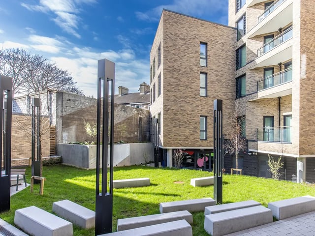 Modern brick building with lawn and benches Exterior at Brewers Close in Dublin Student Accommodation