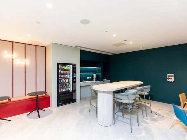 Vending machine neon sign communal table and chairs lounge at Brewers Close in Dublin Student Accommodation