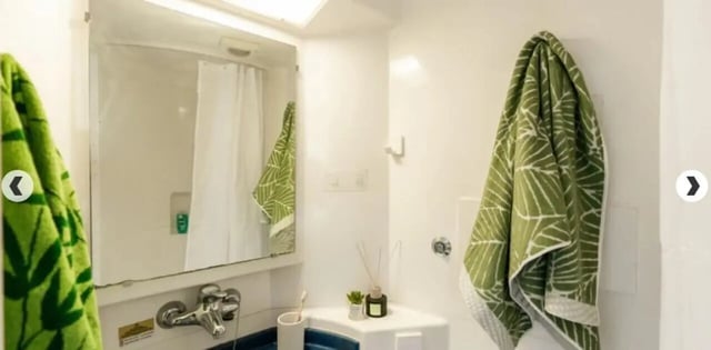 Green patterned towels sink faucet and shower curtain bathroom at Coopers Court in London Student Accommodation