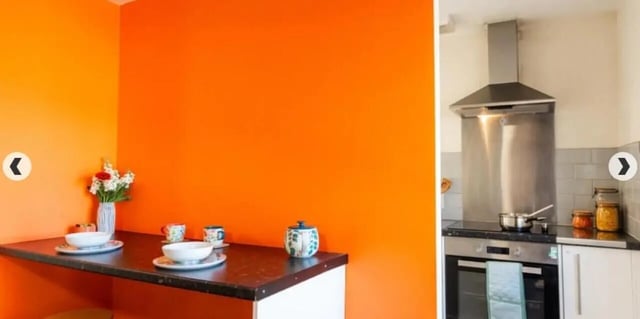 Orange walls plates cups teapot cooker kitchen at Coopers Court in London Student Accommodation