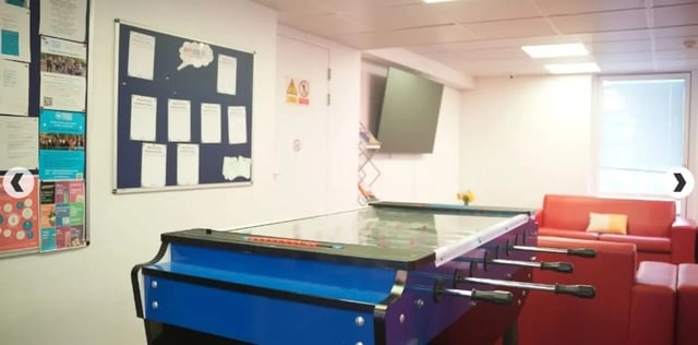 Foosball table sofas and bulletin board common area at Dinwiddy House in London Student Accommodation