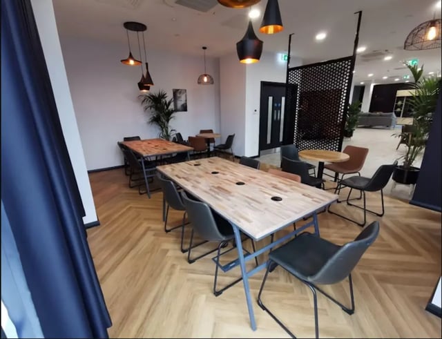 Wooden tables and chairs communal area at Little Patrick Street in Belfast Student Accommodation