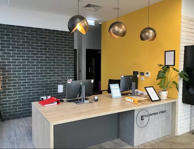 Reception desk with computers and plant reception area at Little Patrick Street in Belfast Student Accommodation