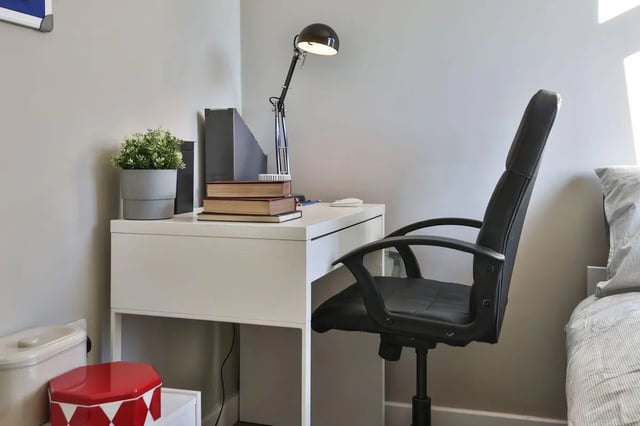 Desk lamp books plant and chair study area at Library Lofts in Exeter Student Accommodation