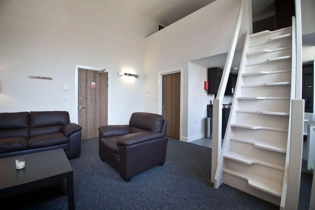 Leather sofas chairs coffee table stairs living room at Dean Clarke Lofts in Exeter Student Accommodation