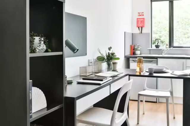 Desk bookshelf plants kitchen living area at Hayward House in Liverpool Student Accommodation
