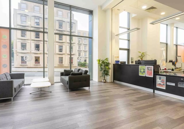 Reception area with couches and a reception desk at iQ Astor House in Plymouth Student Accommodation