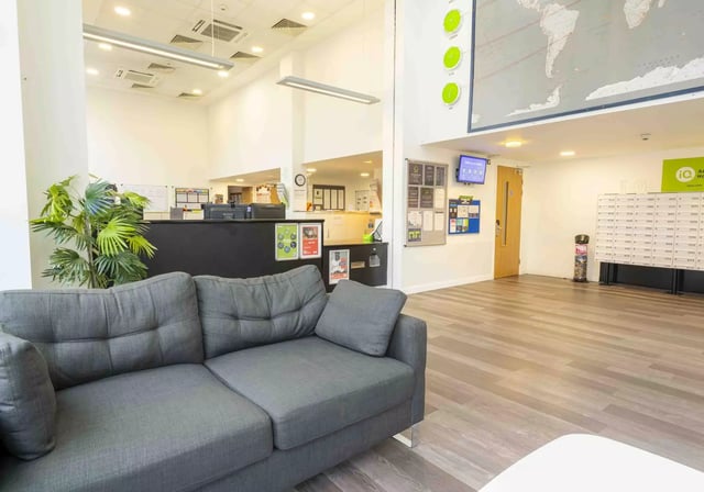 Sofa reception desk plants world map reception area at iQ Astor House in Plymouth Student Accommodation