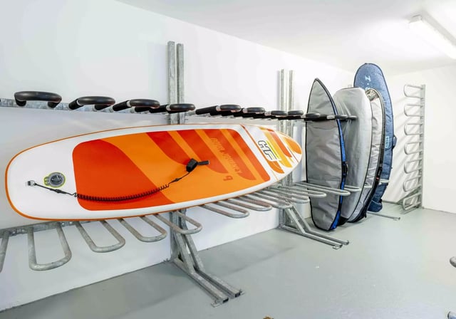 Orange and white paddleboard on racks storage area at iQ Astor House in Plymouth Student Accommodation