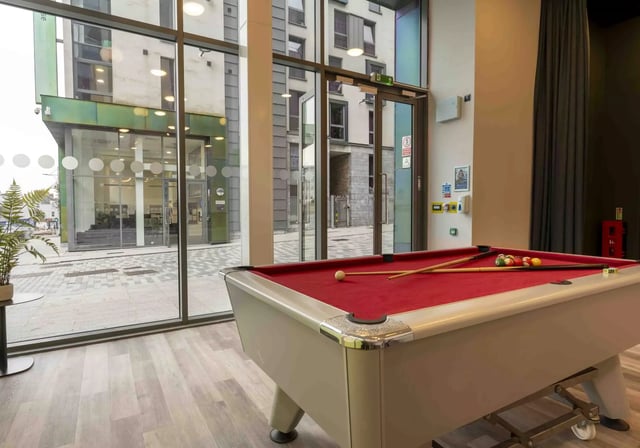 Red pool table with cues and balls recreation area at iQ Astor House in Plymouth Student Accommodation