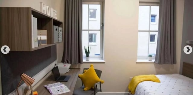 Desk shelf laptop bed with yellow blanket Bedroom at Lilian Knowles House in London Student Accommodation