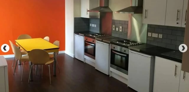 Yellow table chairs ovens counters and hoods kitchen at Alliance House in London Student Accommodation
