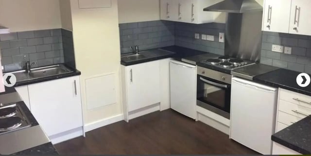 White cabinets sink stove fridge and dark tile kitchen at Alliance House in London Student Accommodation