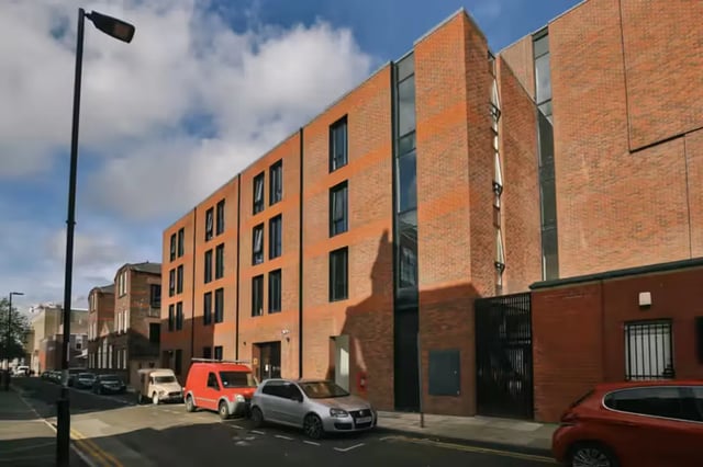 Modern brick building with cars parked outside exterior at Maple House in Liverpool Student Accommodation