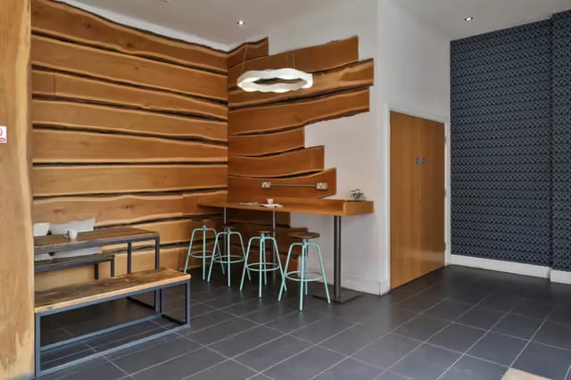 Wooden wall tables stools and benches communal area at Maple House in Liverpool Student Accommodation
