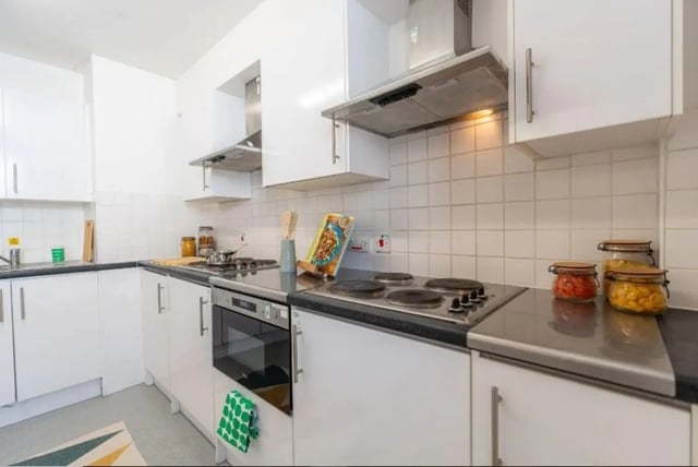 White kitchen cabinets electric stove jars of food kitchen at The Craft Building in London Student Accommodation