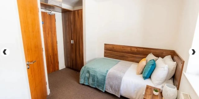Bed with wooden headboard closet and doors bedroom at The Craft Building in London Student Accommodation