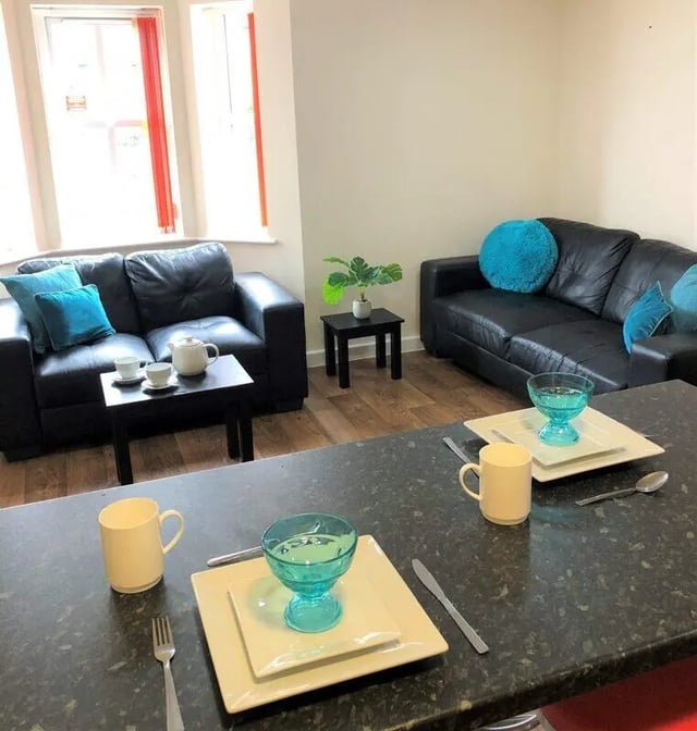 Black couches with blue pillows and teapot living area at Waterside Court in Chester Student Accommodation