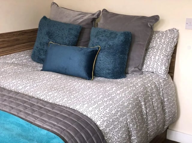 Bed with grey and blue cushions bedroom at Waterside Court in Chester Student Accommodation