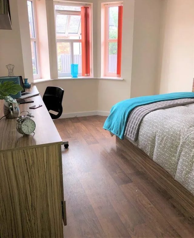 Desk with alarm clock and bed Bedroom at Waterside Court in Chester Student Accommodation