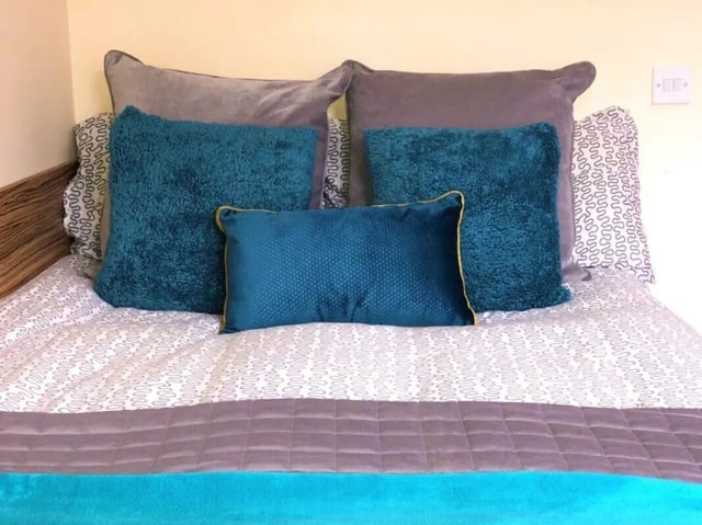 Teal and grey pillows on a patterned bed bedroom at Waterside Court in Chester Student Accommodation