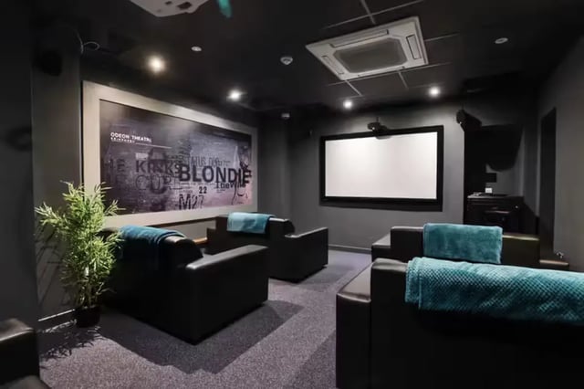 Black leather seating with teal blankets cinema room at Buccleuch Street in Edinburgh Student Accommodation