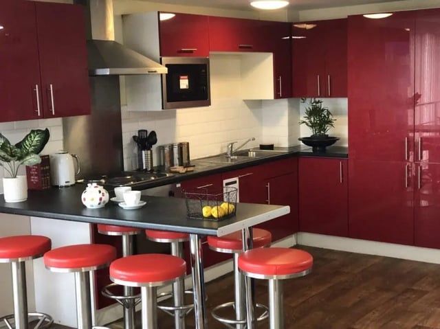 Red cabinets microwave stools counter kitchen area at Falkland House in Liverpool Student Accommodation