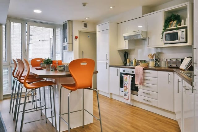 Modern kitchen with orange bar stools and counter Kitchen at 77 Penny Street in Lancaster Student Accommodation