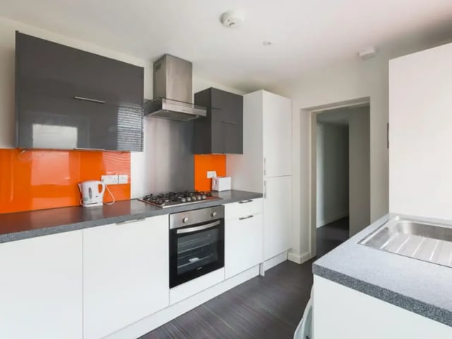 Modern white cabinets grey countertops orange backsplash kitchen at 26 Beresford Street in Stoke-On-Trent Student Accommodation