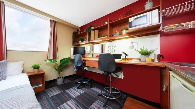 Desk chairs microwave bed plants desk area bedroom at Market Way in Coventry Student Accommodation