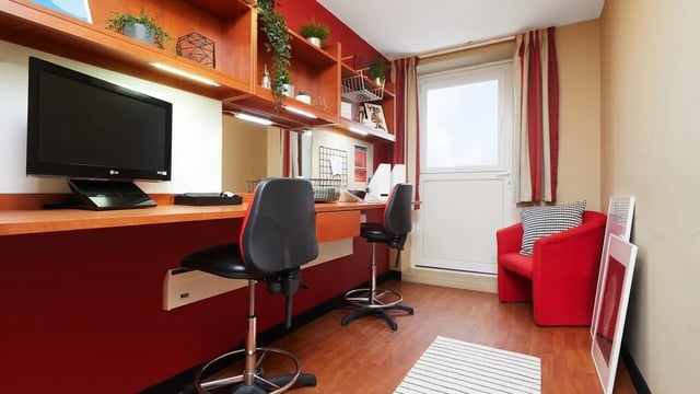 Desk with chairs and red armchair living room at Market Way in Coventry Student Accommodation