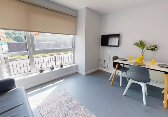 Sofa rug dining table and chairs living area at iQ Fiveways House in Wolverhampton Student Accommodation