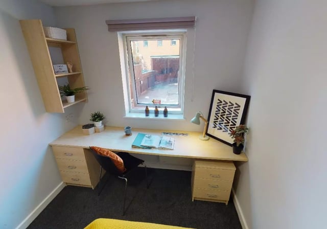 Desk with drawers shelf lamp and framed art study area at iQ Fiveways House in Wolverhampton Student Accommodation