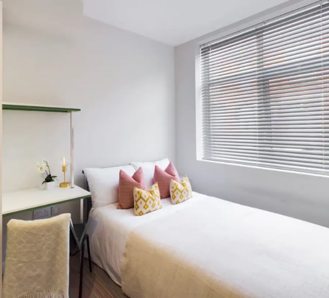 Bed with pillows desk chair and lamp bedroom at 29 Guildford Street in Stoke-On-Trent Student Accommodation