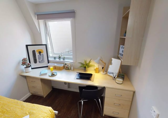 Desk with laptop lamp mirror and framed art study area at iQ Great Newton House in Liverpool Student Accommodation