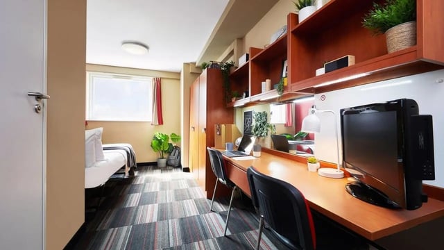 Desk with computer bed and plants bedroom at Corporation Village in Coventry Student Accommodation
