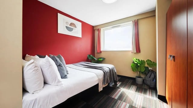 Bed with pillows plants and closet bedroom at Corporation Village in Coventry Student Accommodation