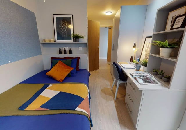 Bed desk plants shelves and artwork bedroom at iQ Magenta House in London Student Accommodation