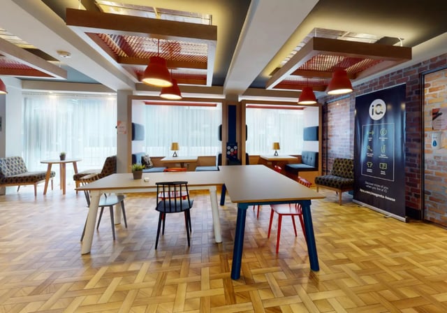 Communal tables and chairs with seating booths living room at iQ Magenta House in London Student Accommodation