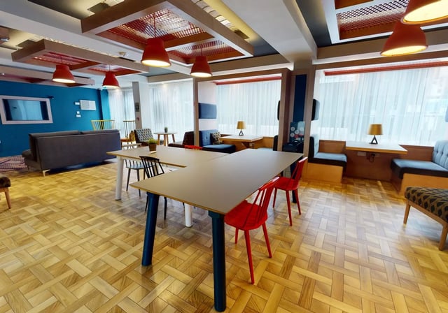 Desks sofas chairs and pendant lights common area living room at iQ Magenta House in London Student Accommodation